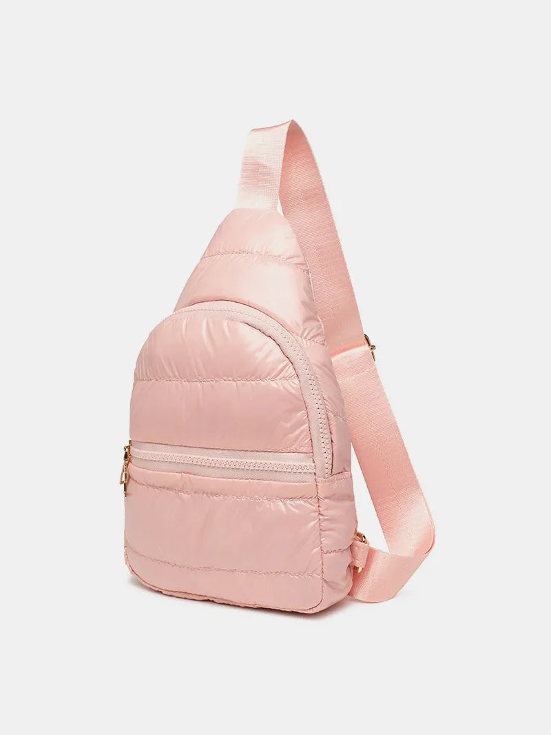 Glossy padded sling bag in pink with adjustable strap and zippered pockets.