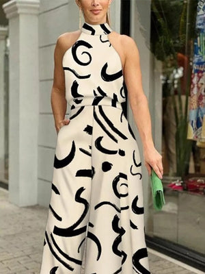 White halter neck romper with black abstract print and wide legs.