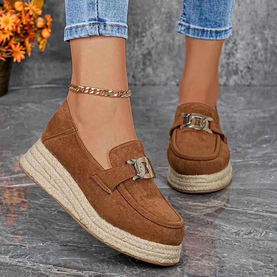 Brown round toe platform loafers with chain detail and espadrille sole.