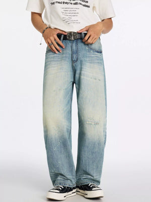 Men's relaxed wide-leg jeans in blue denim with distressed details and a faded wash.
