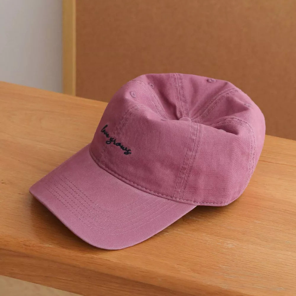 Raspberry purple cotton baseball cap with embroidered 'love grows' detail