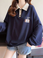 Navy waffle-knit polo sweatshirt with contrast collar and button placket, featuring a graphic patch.