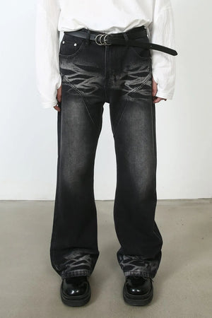 Dark distressed flare jeans with stitch detail and a black belt.