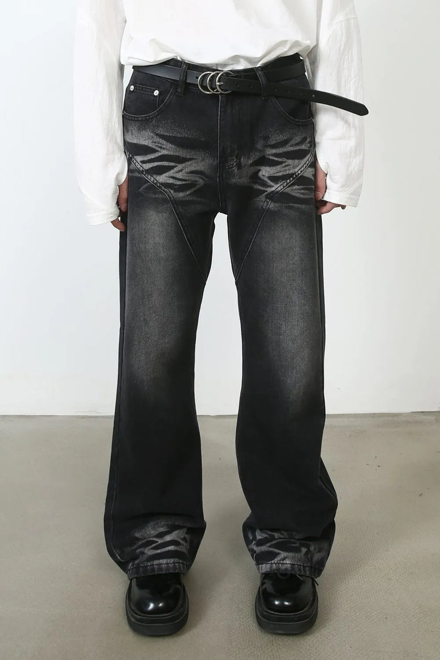 Dark distressed flare jeans with stitch detail and a black belt.
