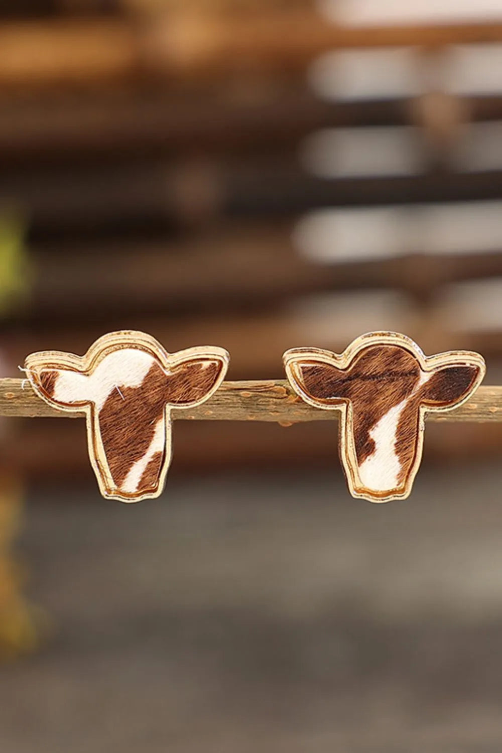 Cowhide silhouette stud earrings in copper with brown and white pattern.