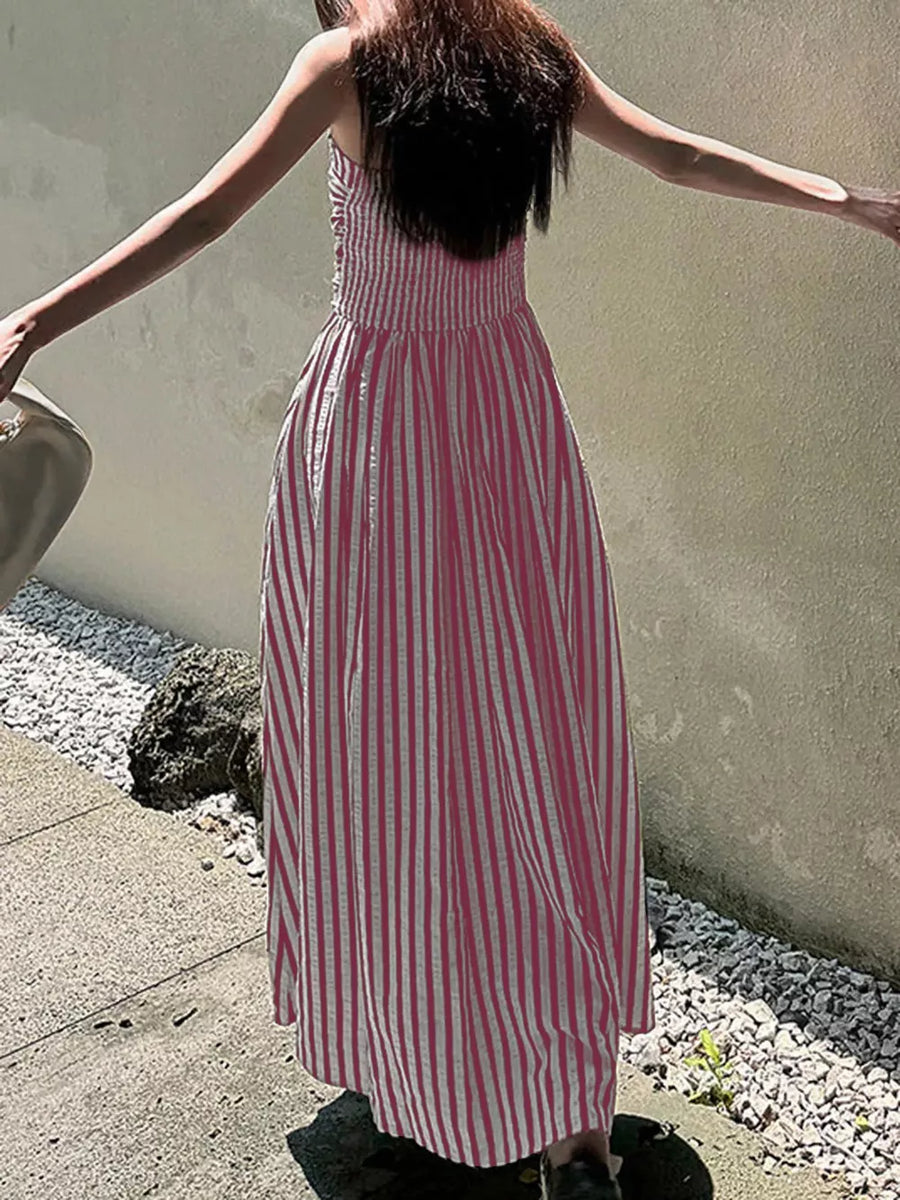Pink striped maxi dress with smocked bodice and side slit.
