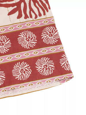 Charming floral tie-front wide-leg romper in red with white floral and eye pattern.