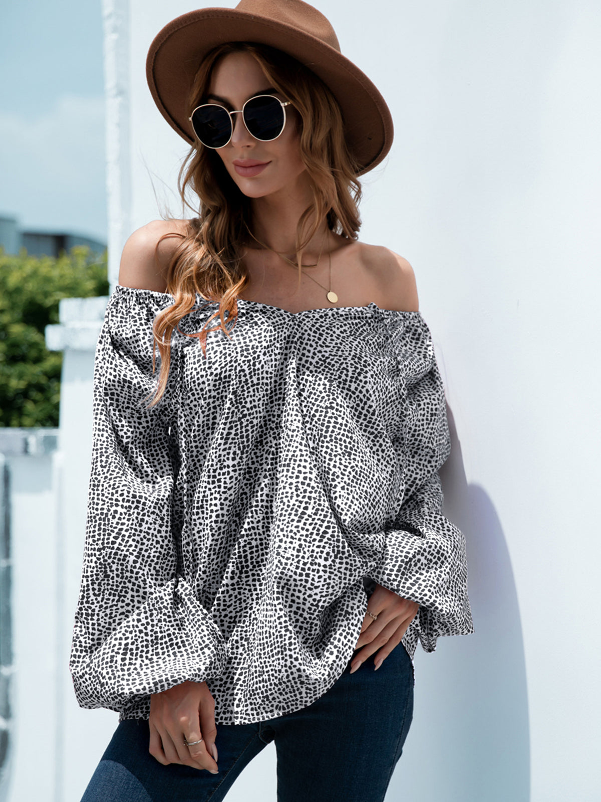 Off-the-shoulder black spotted print blouson top with balloon sleeves.