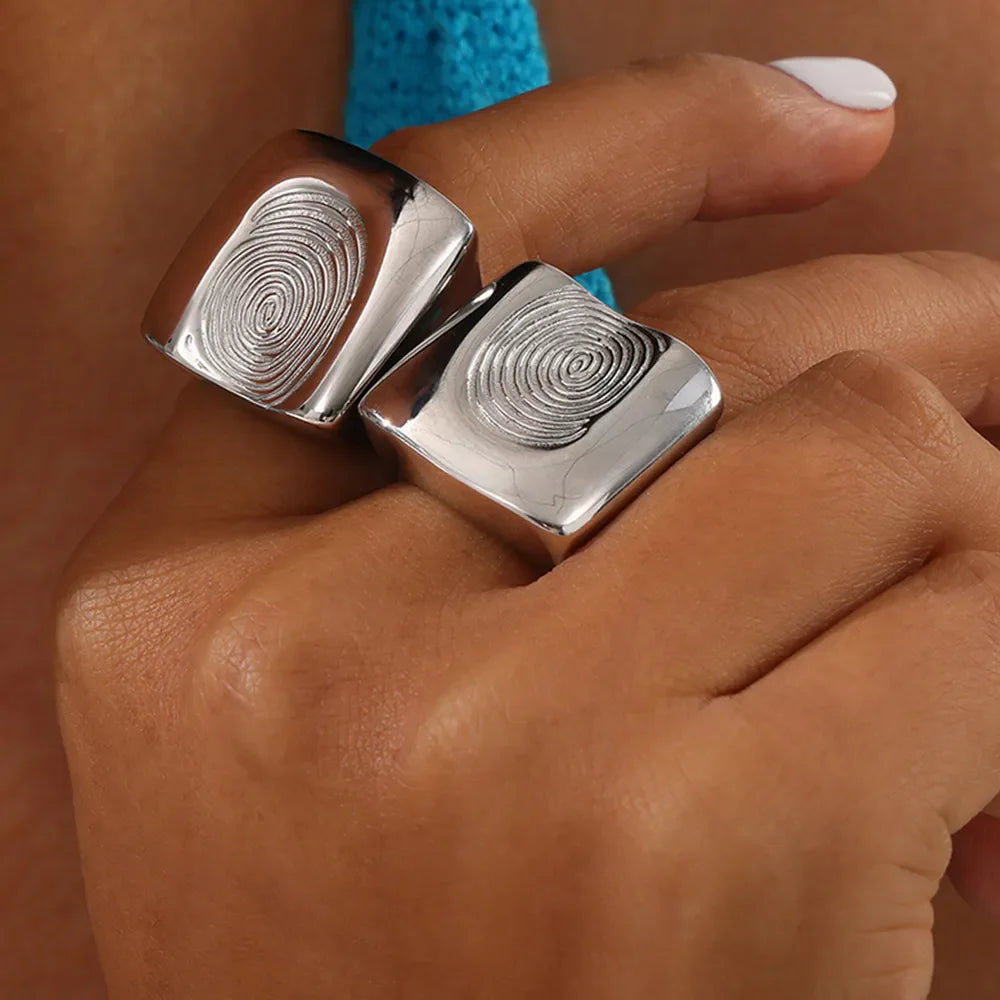 Silver sculpted fingerprint signet rings on a hand