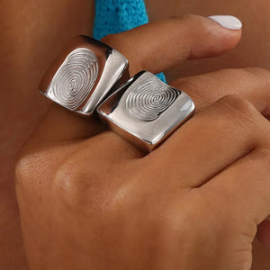 Silver sculpted fingerprint signet rings on a hand