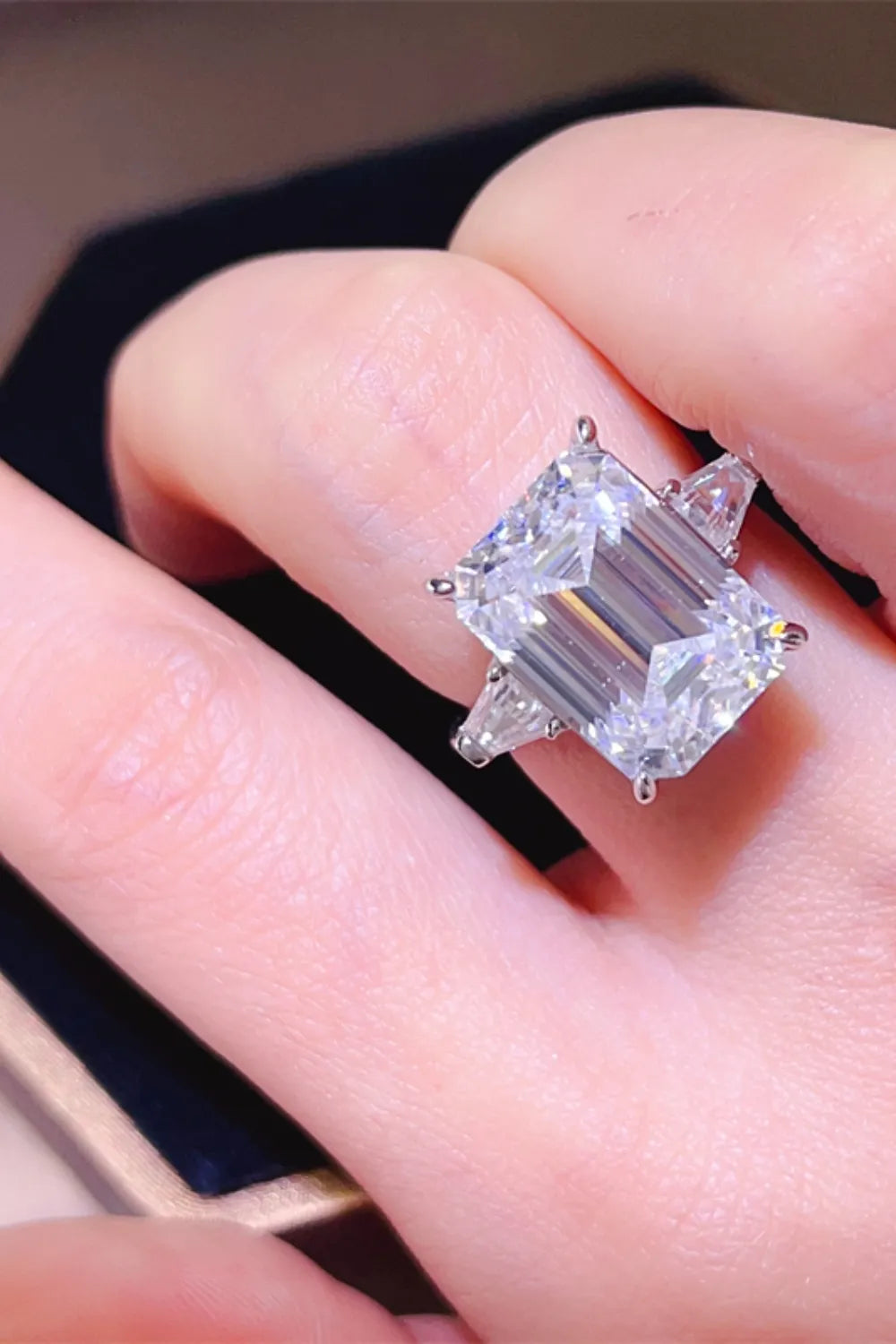 Silver ring with emerald cut diamond and side stones