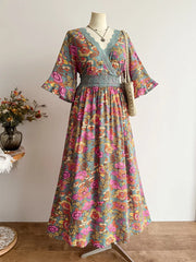 Floral lace-trimmed surplice maxi dress in deep rose with a bohemian floral print and wide sleeves.