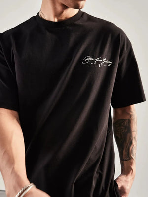 Black oversized graphic tee with white script print on chest and back print detail.