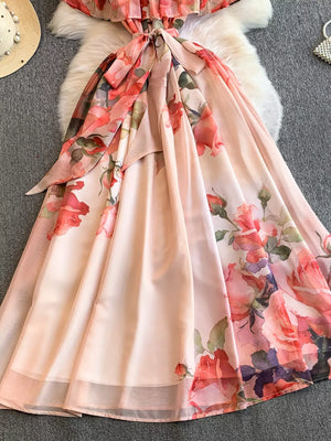 Botanical off-shoulder dress in light pink with a floral print and a bow detail.