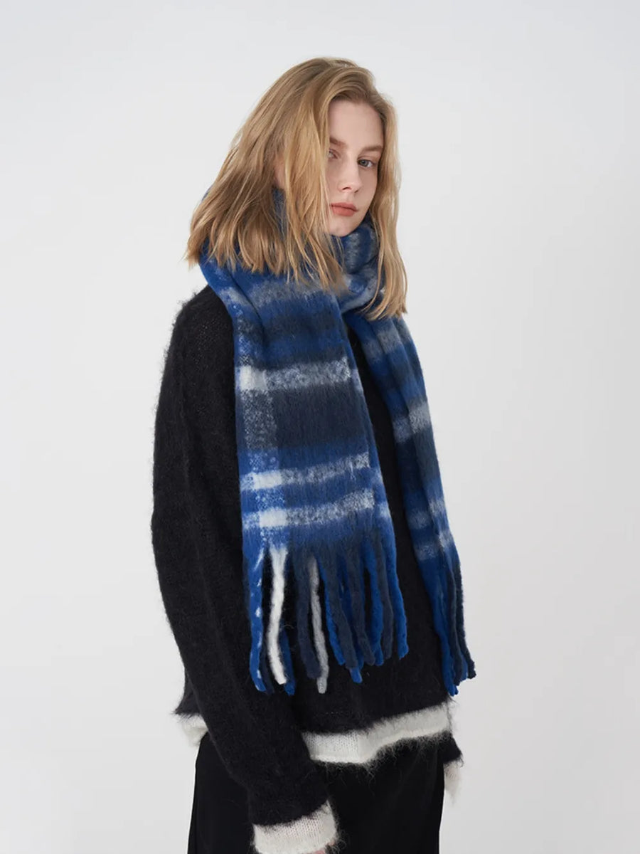 Textured plaid fringe scarf in blue/white/gray plaid with soft fringe detail.