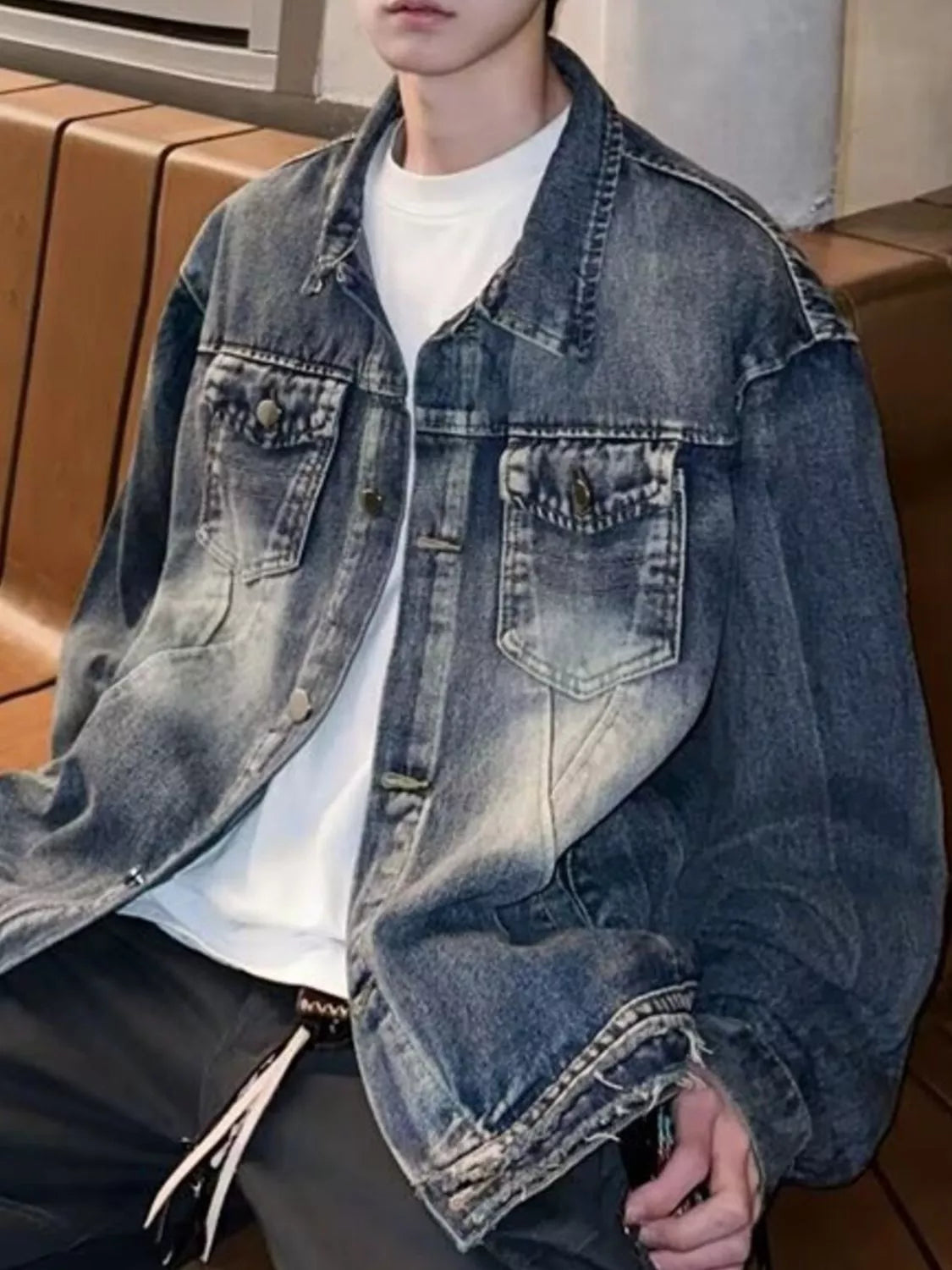 Men's blue vintage washed denim trucker jacket with chest pockets and distressed details.