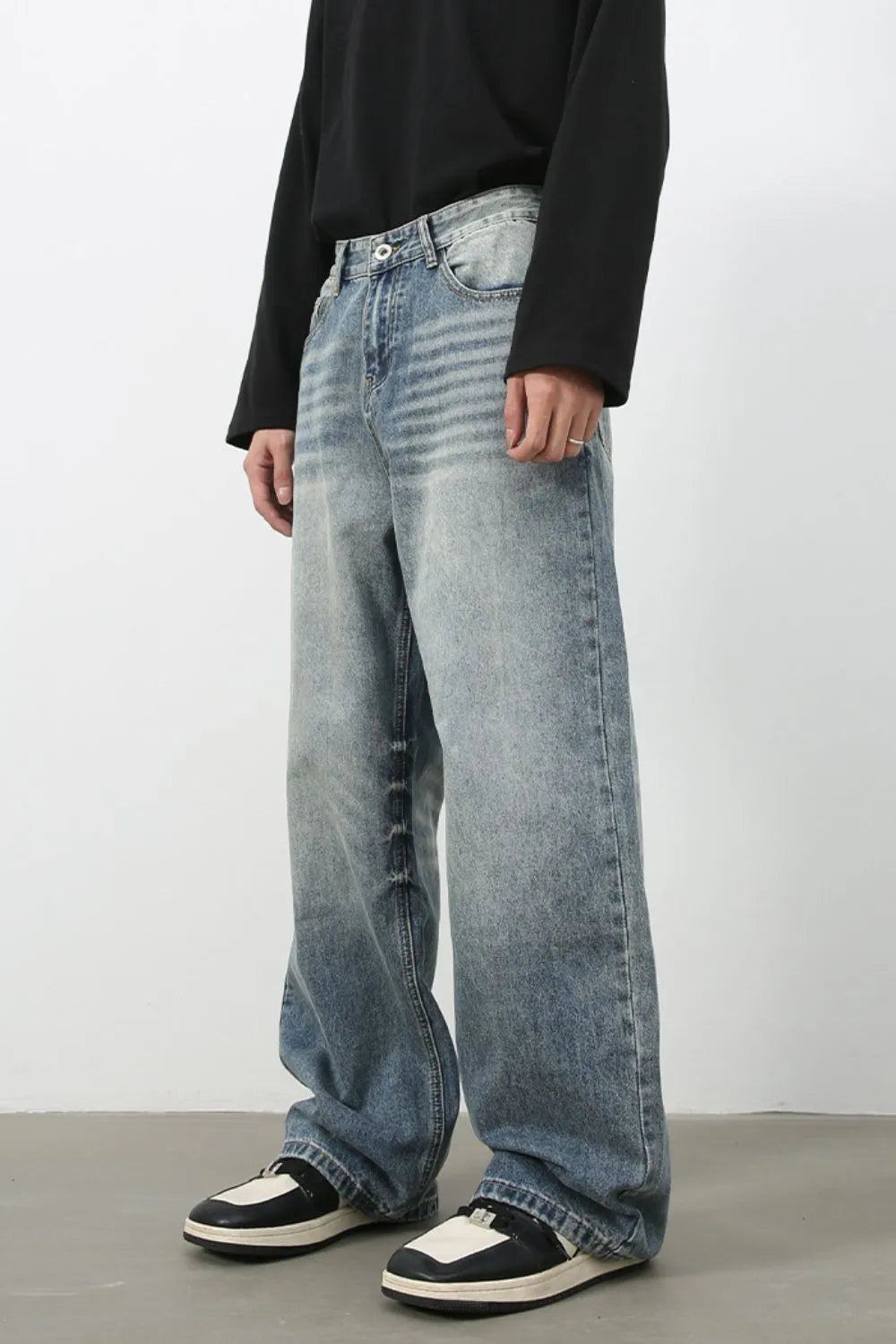 Baggy wash denim jeans in medium blue with a relaxed fit and faded details.