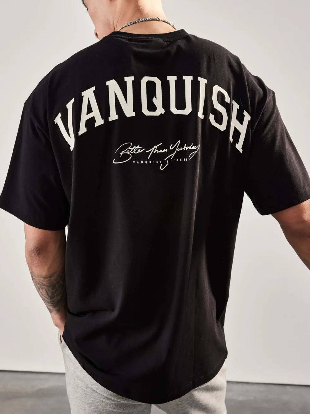 Black oversized graphic tee with "Vanquish" and "Better Than Yesterday" back print