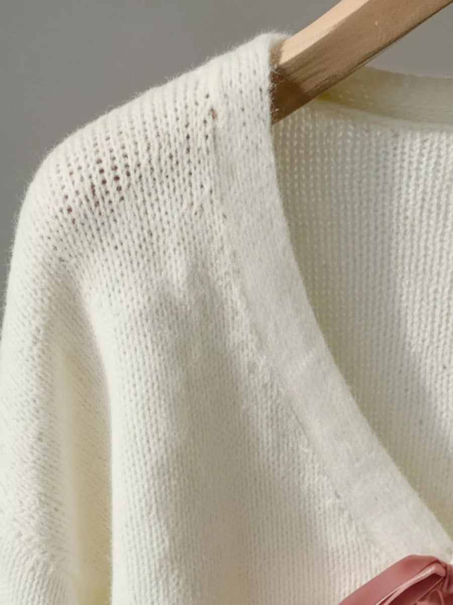 Beige V-neck acrylic knit cardigan with pink bow detail