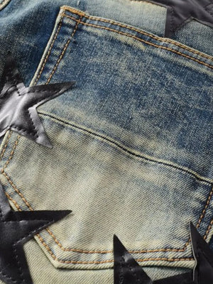 Medium wash denim jeans with black star appliqué details and contrast stitching.