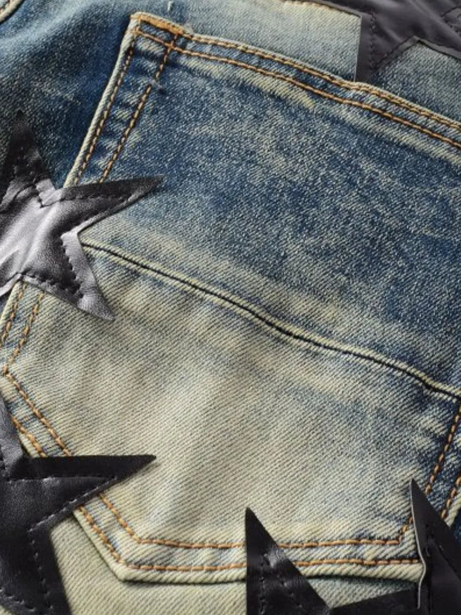 Medium wash denim jeans with black star appliqué details and contrast stitching.