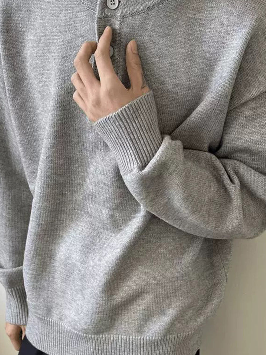Grey knit henley sweater with button closure and ribbed cuffs