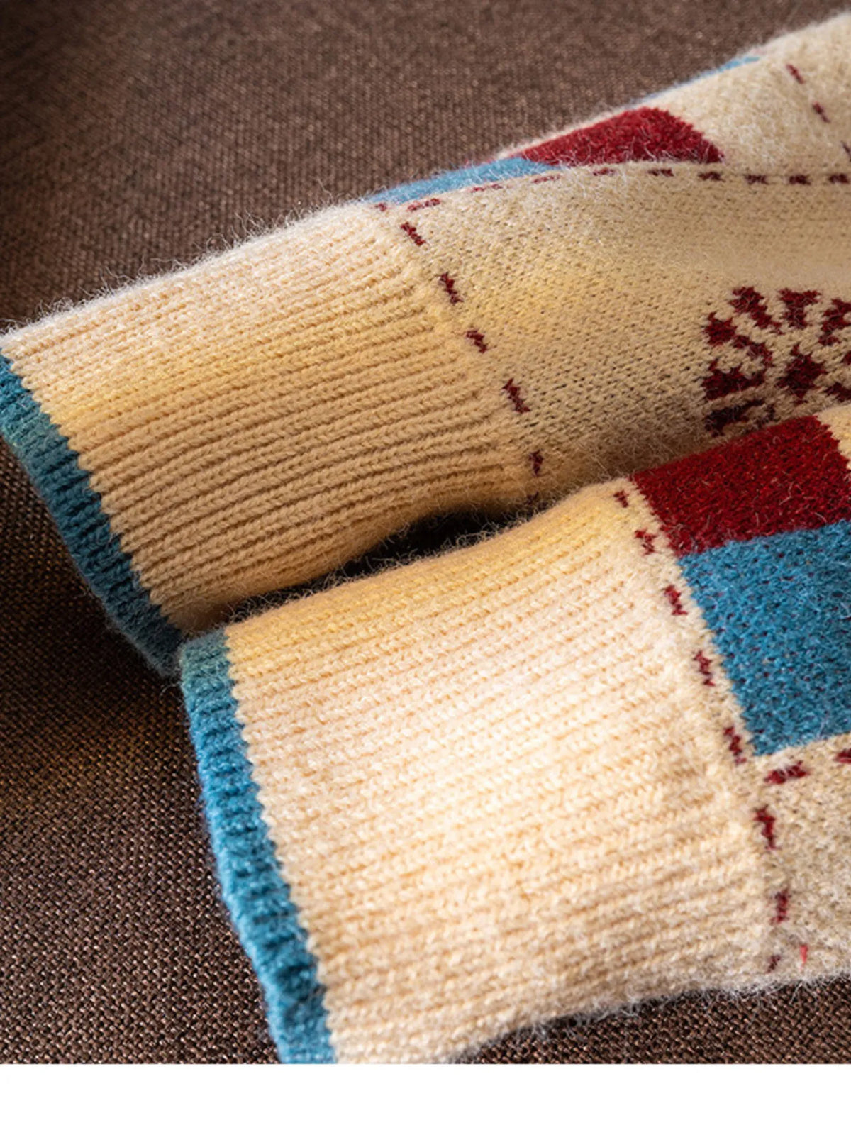 Cream sweater with red heart and blue checkered pattern, ribbed cuffs.
