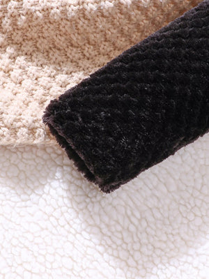 Children's fuzzy black cardigan sleeve detail with beige knit and sherpa lining.