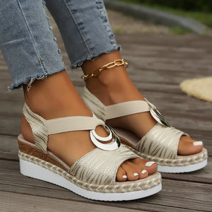 Beige espadrille wedges with metallic leaf pattern and ring detail.
