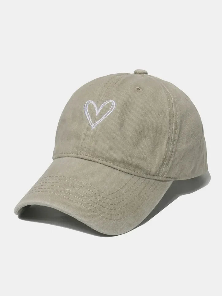 Beige washed cotton baseball cap with white embroidered heart detail.
