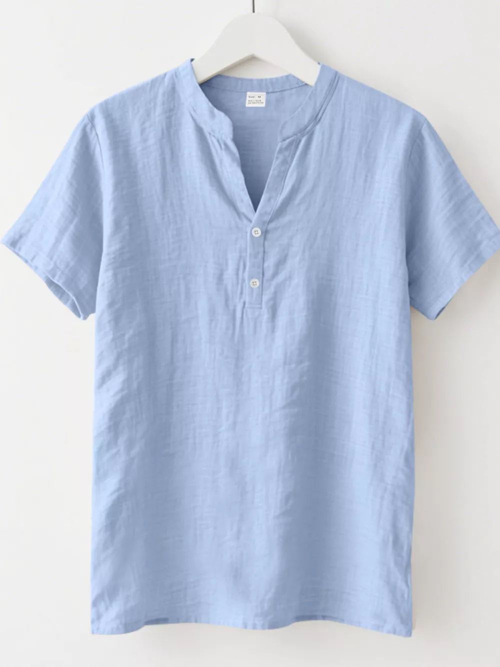 Light blue relaxed-fit men's short sleeve overshirt with band collar and button detail.