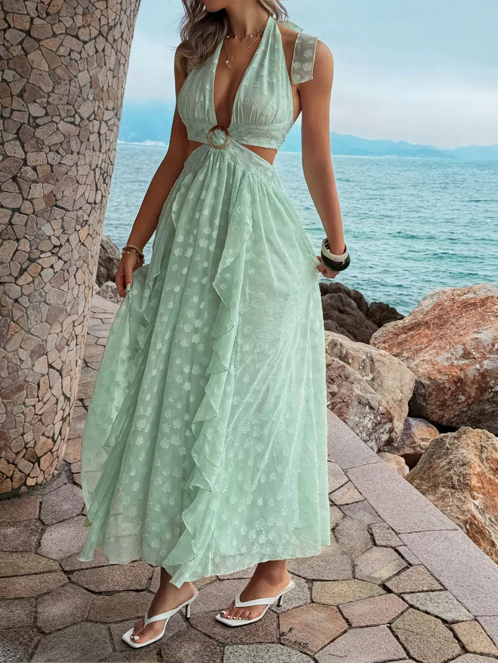 Mint green ruffled halter maxi dress with cutouts and a ring detail.