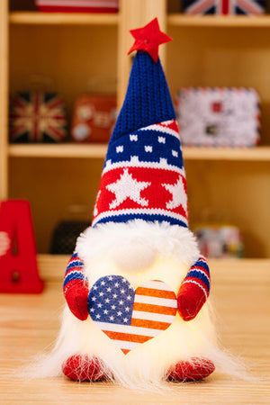 Patriotic gnome with LED heart, red white and blue knit hat with star, and fluffy beard.