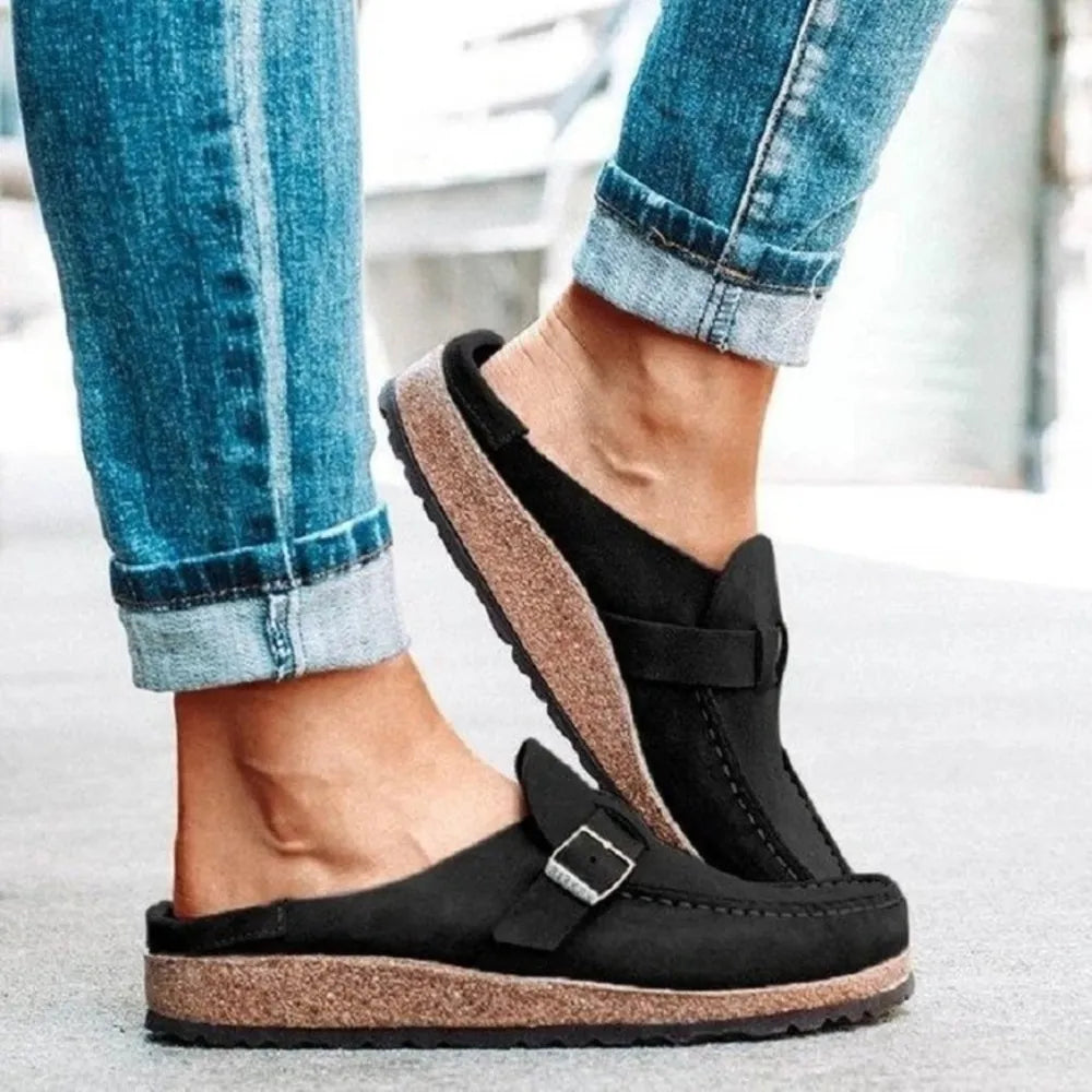 Black suede buckle mule loafers with cork sole.