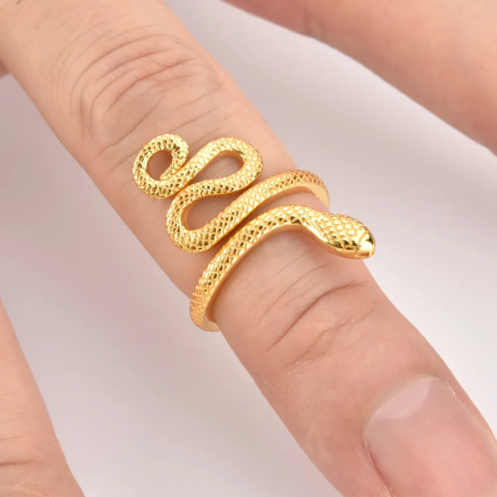 Gold coiled snake ring with textured scales on a finger