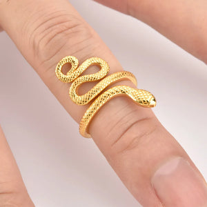 Gold coiled snake ring with textured scales on a finger