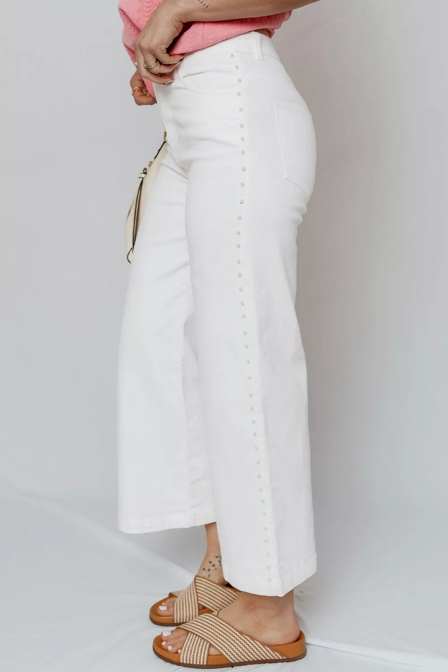 White relaxed fit ankle-length jeans with pearl embellishments down the side seam.