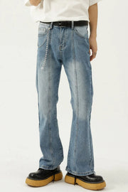 Medium wash denim flare jeans with prominent seam details and a chain accessory.