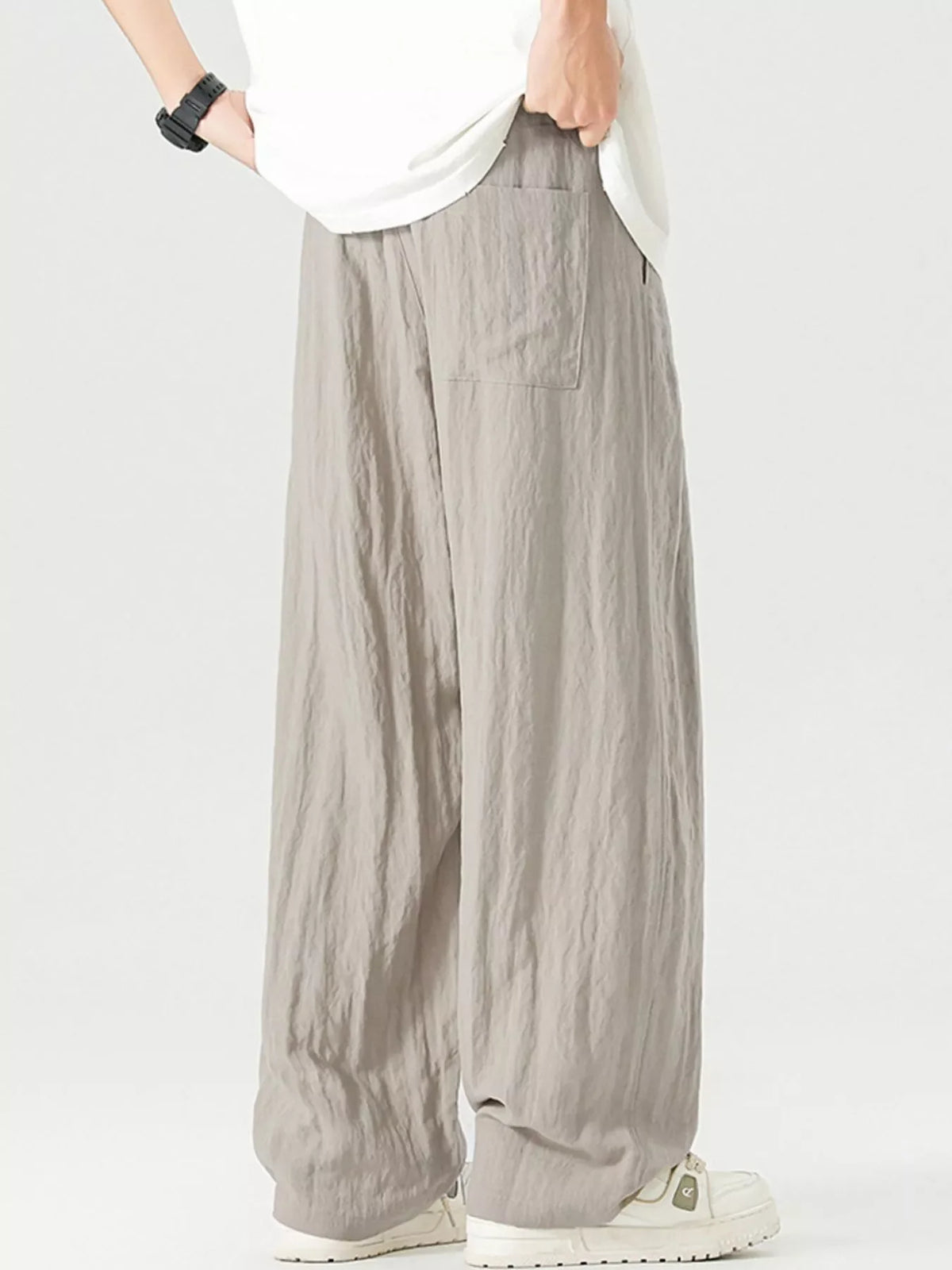 Lightweight wide-leg trousers in light gray with a drawstring waist and pocket detail.