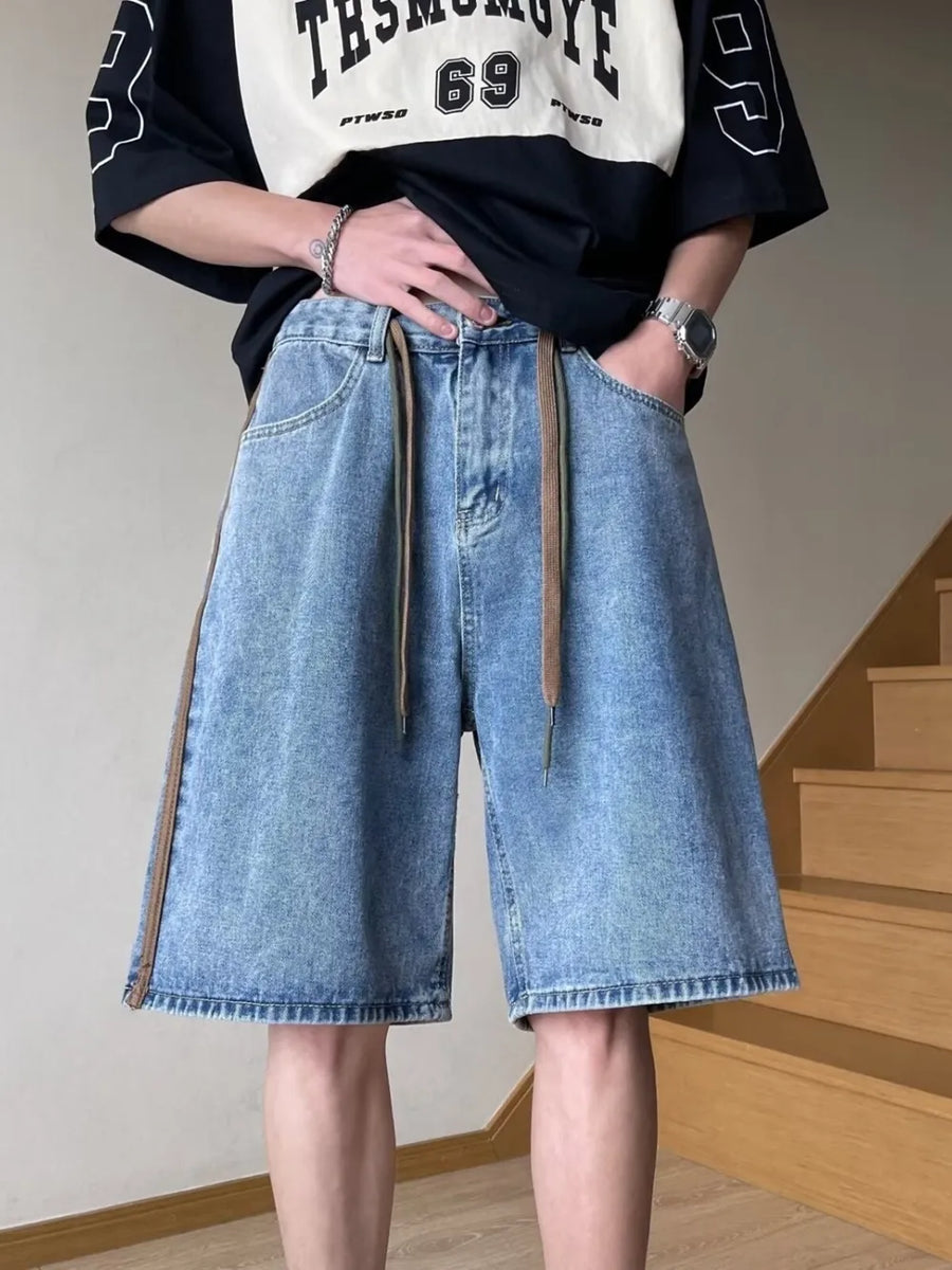 Men's blue wide-leg denim shorts with drawstring and side stripe detail.
