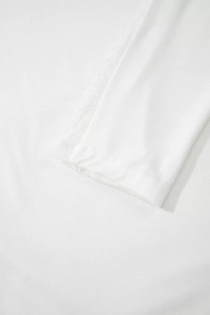 White long sleeve shirt with delicate lace trim on the shoulder and cuff.