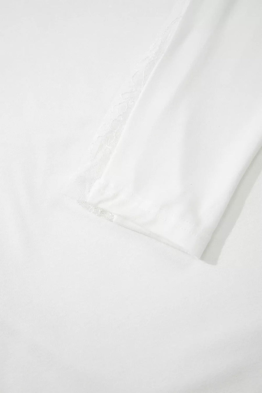 White long sleeve shirt with delicate lace trim on the shoulder and cuff.