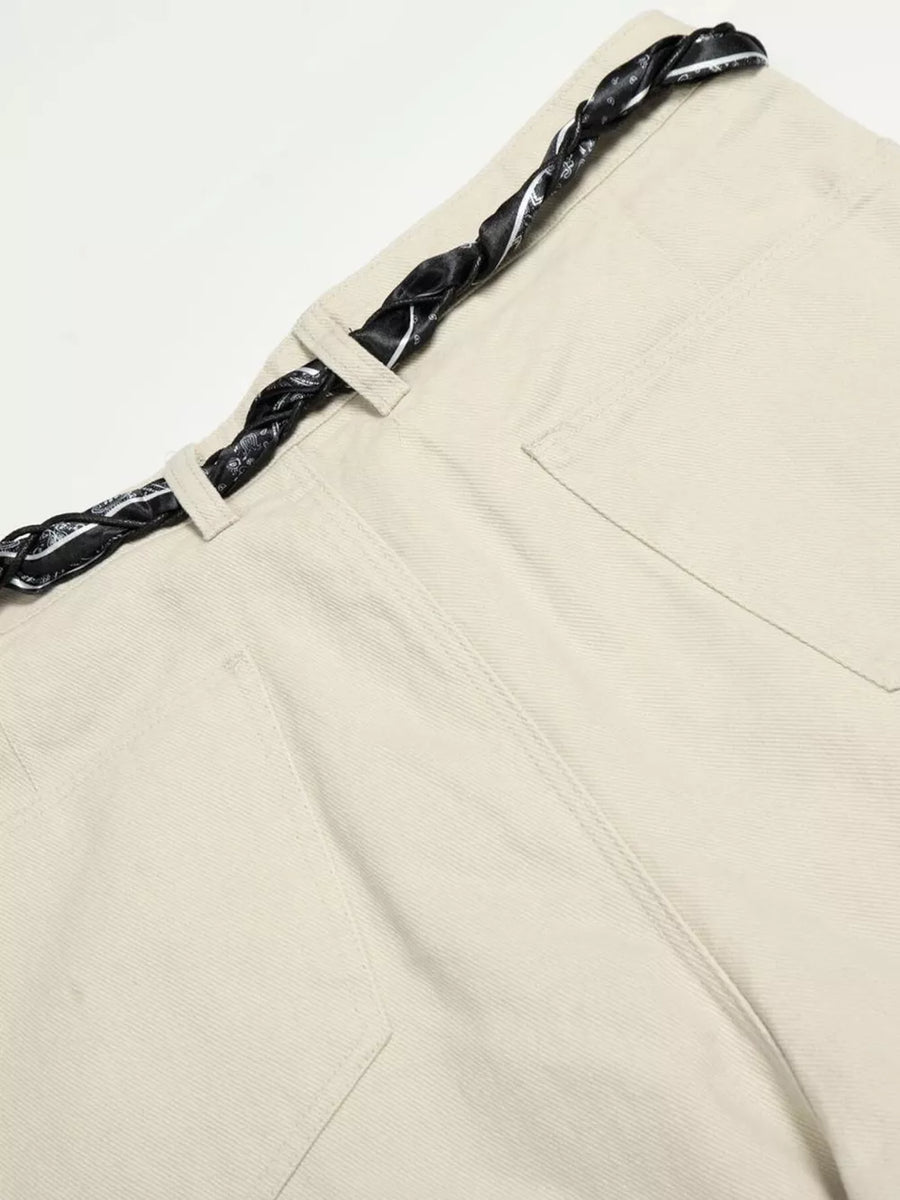 Cream white maternity pants with a black patterned braided belt and wide-leg cut.