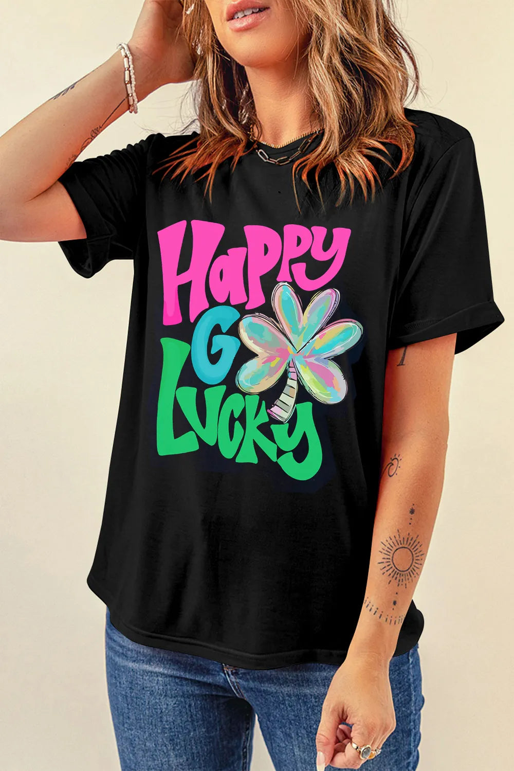 Black t-shirt with rolled sleeves and a colorful "Happy Go Lucky" clover graphic.