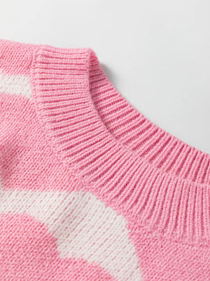 Pink acrylic knit sweater with white heart pattern and ribbed crew neck.