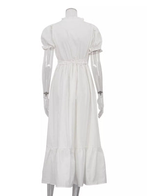 White cotton midi dress with puff sleeves, ruffled neckline, and tiered hem