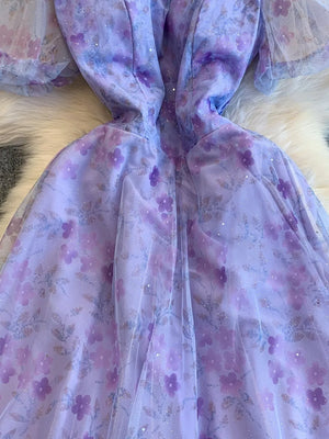 Purple floral maxi dress with sweetheart neckline and sheer sleeves.