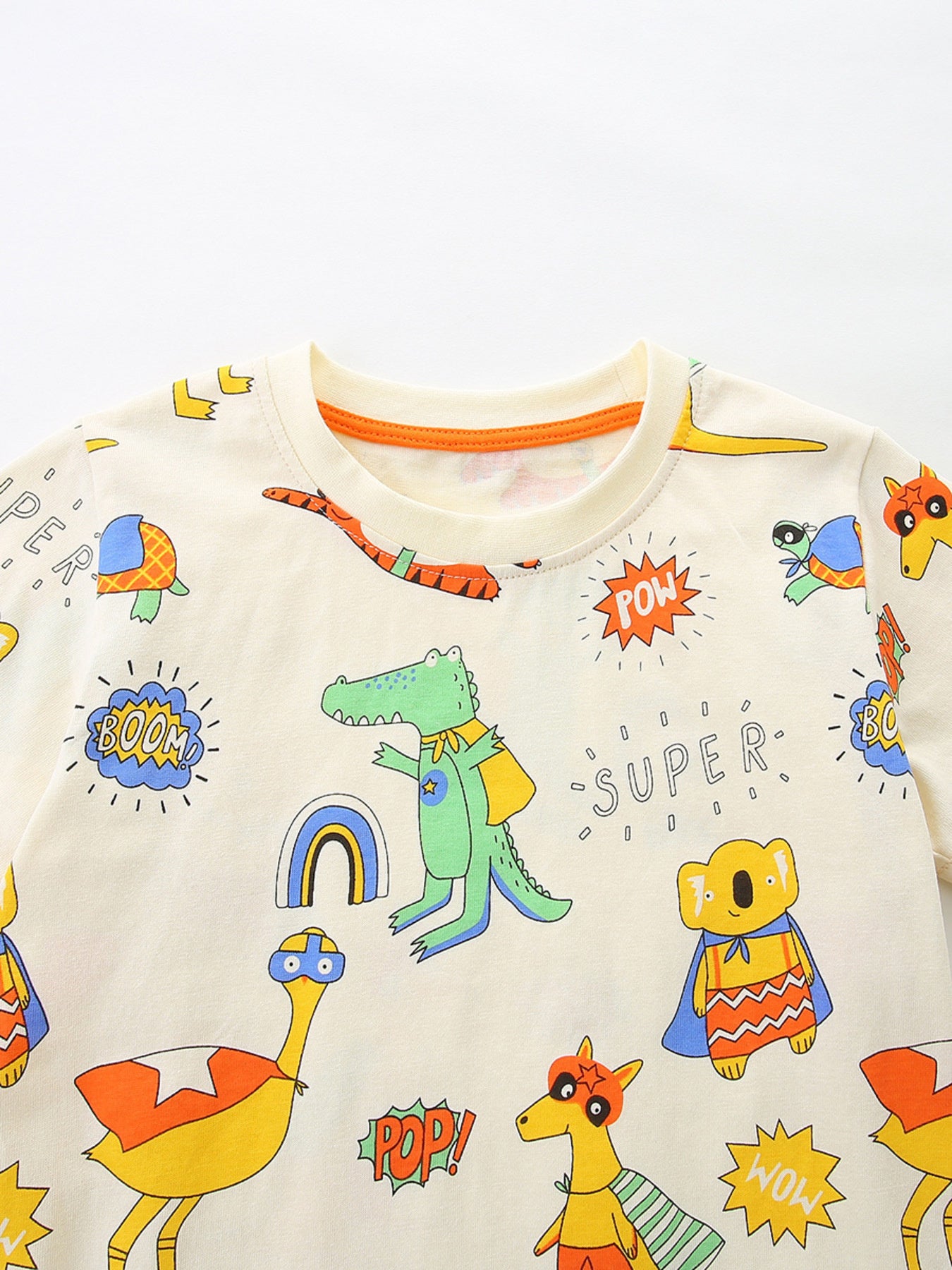 Children's beige crew neck t-shirt with a fun animal print featuring superheroes like a crocodile, koala, and ostrich.