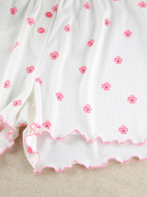 White ribbed knit shorts with pink floral print and frill trim.