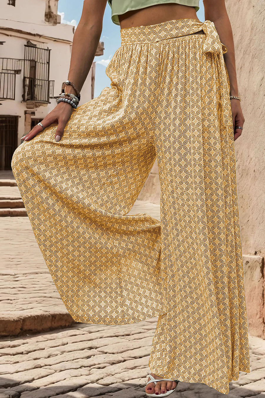 Yellow geometric print wide-leg palazzo trousers with a tie waist detail.